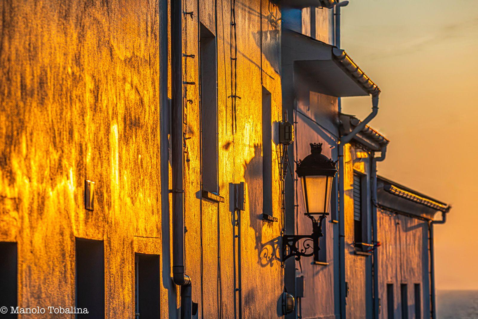 Atardecer en Tapia de Casariego, sol reflejando en las casas