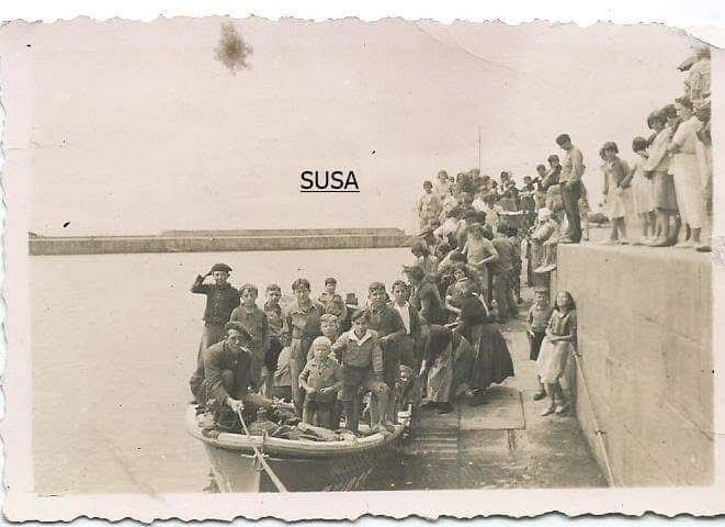 Grupo de niños en el muelle de Tapia subiendo a una lancha