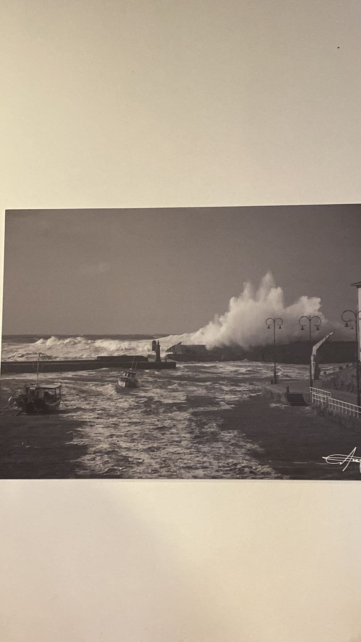 Ola golpeando el faro rojo de Tpaia de Casariego