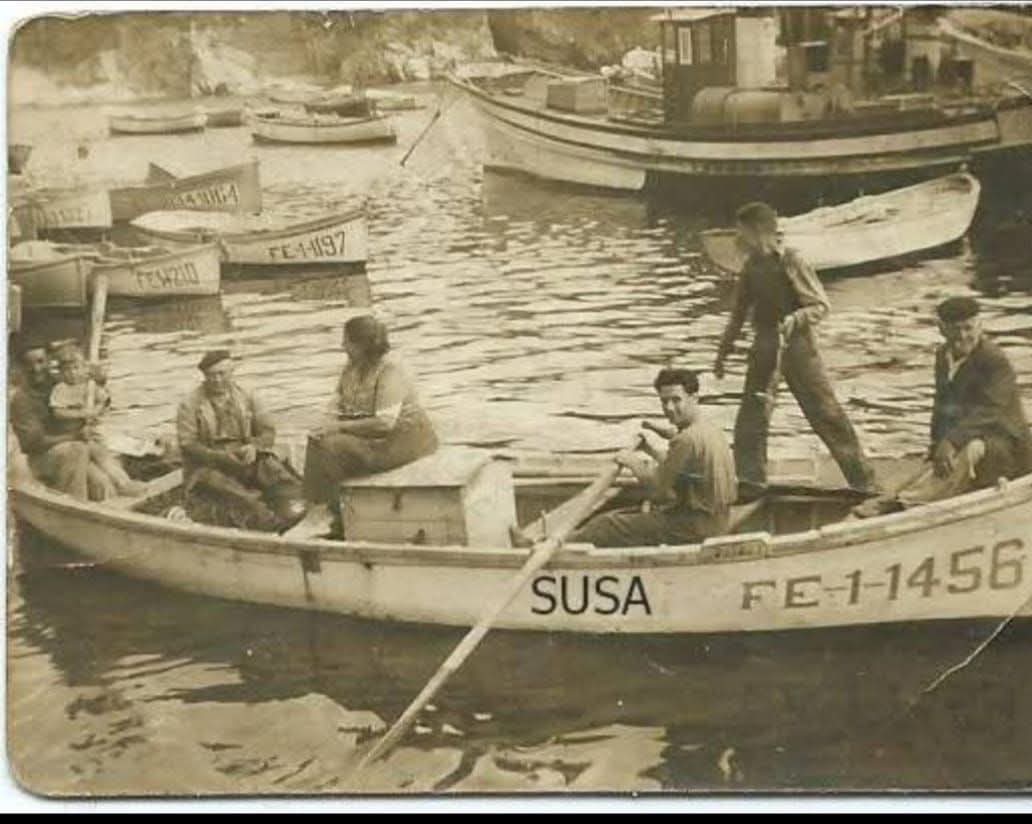 Marineros en lancha en el muelle de Tapia de Casariego