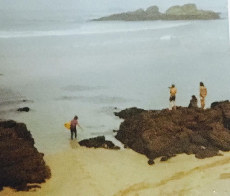 Surfista entrando en el agua, observado por aficionados en Tapia de Casariego, Asturias